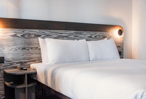 a bed with white pillows and a wooden headboard at Park Heights by the Warren Collection in Msida