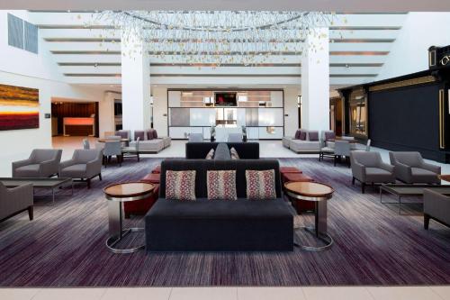 a lobby with a couch and chairs and a piano at Hanover Marriott in Whippany