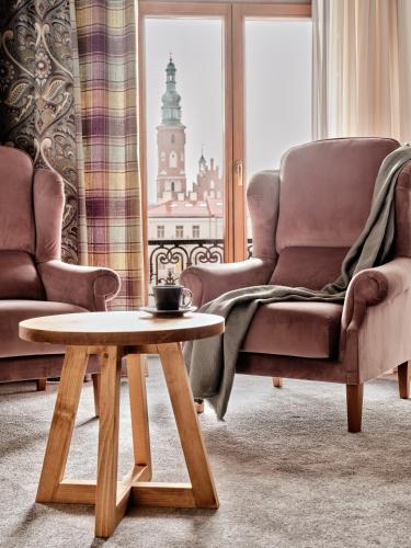 a living room with a chair and a coffee table at Hoppen House Apartamenty w centrum miasta in Radom