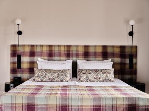 a bedroom with a bed with a plaid blanket and pillows at Hoppen House Apartamenty w centrum miasta in Radom