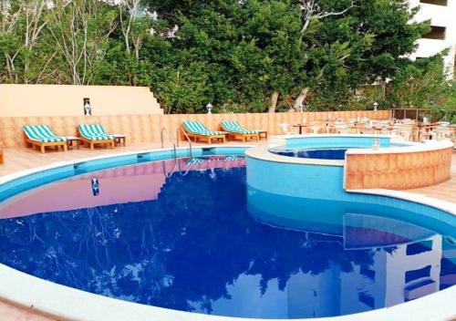朱尼耶的住宿－萬達Spa酒店，一个带椅子的游泳池和一个游泳池