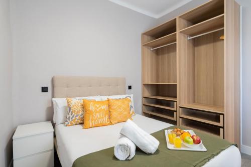 a bedroom with a bed with a tray of fruit on it at dobohomes - Juan de Olias in Madrid