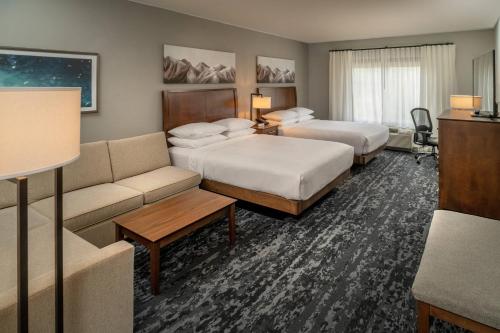 une chambre d'hôtel avec deux lits et un canapé dans l'établissement Delta Hotels by Marriott Huntington Mall, à Barboursville