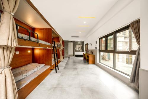a hallway with bunk beds and a large window at Riverside International Youth Hostel阅江老院青年旅舍 in Chongqing