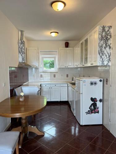 a kitchen with a table and a white refrigerator at Apartments Cvjetković in Mlini