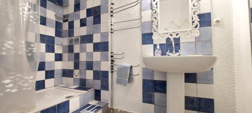 baño con lavabo y azulejos azules y blancos en La miellerie de Léone en Riez