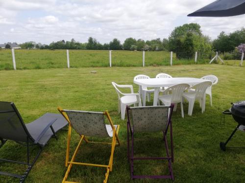 a group of chairs and a white table and chairs at L'Opaline, Jolie Maison avec Jardin 6 pers,10km Honfleur, linge et internet inclus in Beuzeville