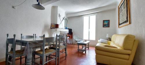 - un salon avec une table à manger et un canapé dans l'établissement La miellerie de Léone, à Riez