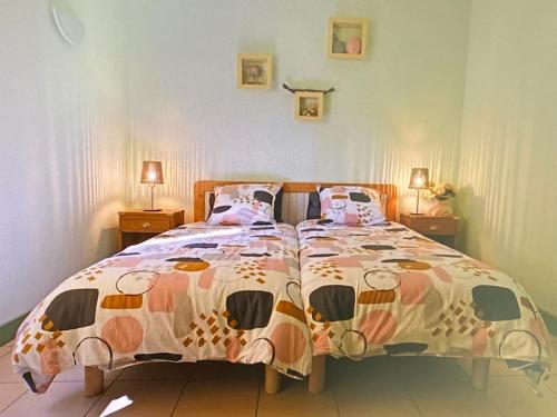 a bedroom with a bed with a colorful comforter at Louise-Angèle in Biscarrosse