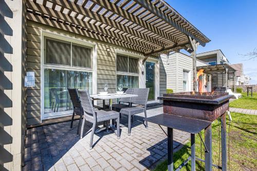 a patio with a table and chairs and a grill at Ramios bitės in Palanga