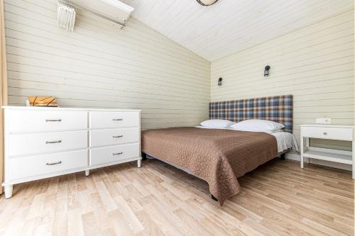 a bedroom with a bed and a dresser in a room at Ramios bitės in Palanga