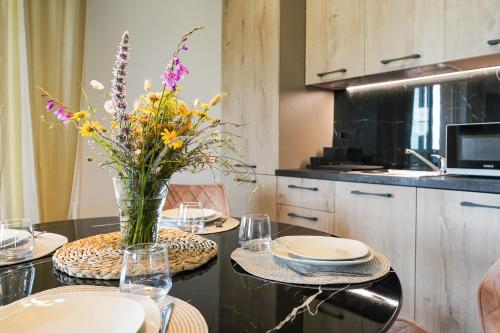 a dining room table with a vase of flowers on it at TEONA Luxury Apartment with 2 rooms and terrace sea view in Sali