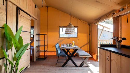 a dining room with a table and chairs in a house at Molecaten Park Waterdunen in Breskens