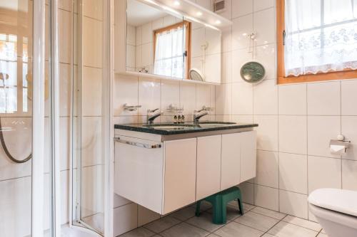 a bathroom with a sink and a shower at Apartment Schneerose - GRIWA RENT AG in Grindelwald