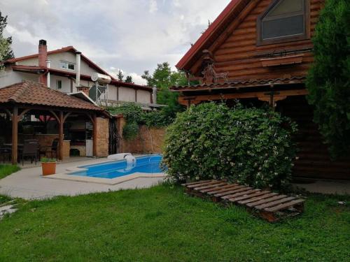 une maison avec une piscine à côté d'une maison dans l'établissement Ξύλινο σπίτι στη Βεροια, à Tagarochórion