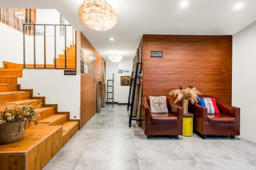 a hallway with two chairs and a staircase at Riverside International Youth Hostel阅江老院青年旅舍 in Chongqing