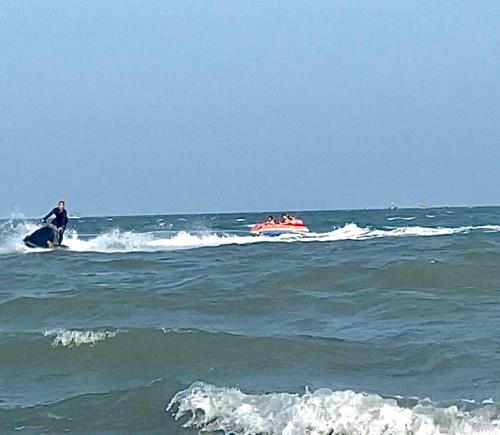 a man riding a jet ski in the ocean with a boat at Las Tortugas, Cozy condominium on Khao Tao beach, Hua Hin in Khao Tao