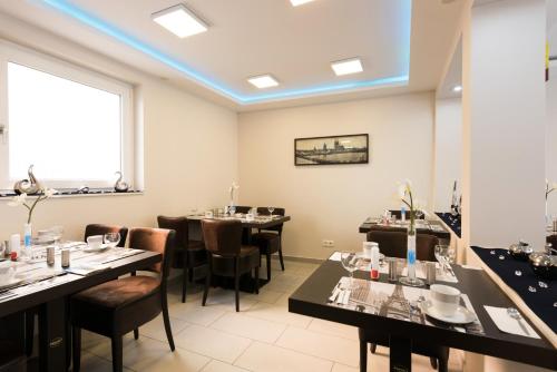a dining room with tables and chairs and a blue ceiling at Bürgerhofhotel in Cologne