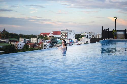 a woman standing in a swimming pool on top of a building at Landmark Vientiane Life Center in Vientiane