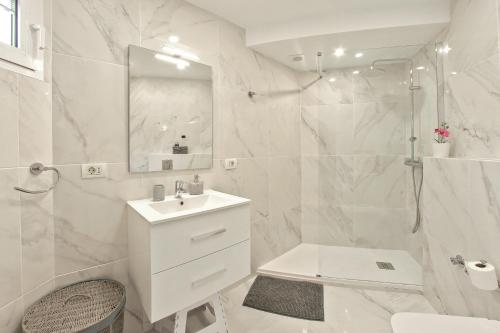a white bathroom with a sink and a shower at AZURE VIEW Ponderosa 719 in Playa Fañabe