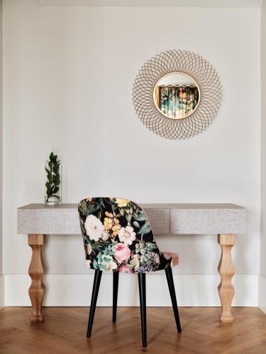 a chair in front of a table with a mirror at Hoppen House Apartamenty w centrum miasta in Radom