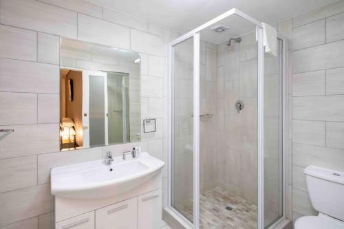 biała łazienka z umywalką i prysznicem w obiekcie Cozy Table mountain view in Cape town w Kapsztadzie