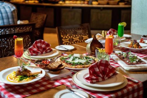 a wooden table with plates of food on it at Sharq Village & Spa, a Ritz-Carlton Hotel in Doha