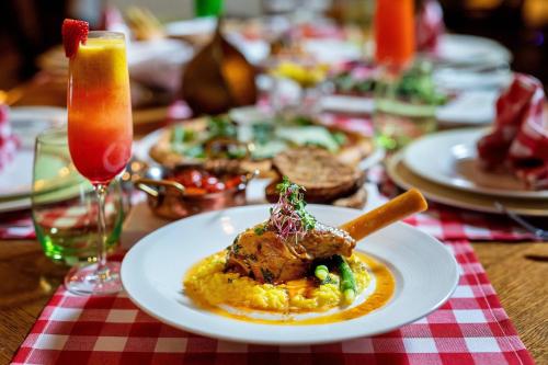 a table with a plate of food and a drink at Sharq Village & Spa, a Ritz-Carlton Hotel in Doha