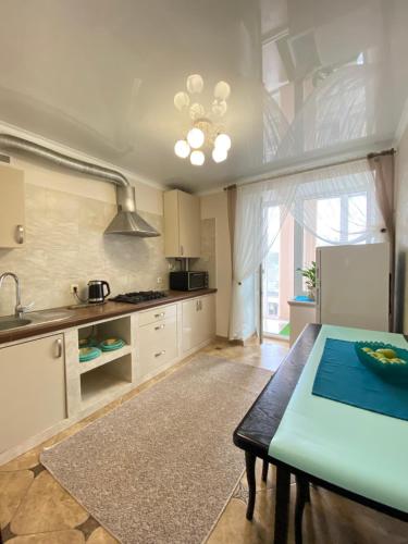 una cocina con una mesa y un refrigerador en Центр. Поруч озеро та парк (5), en Ternopilʼ