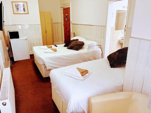 a hotel room with two beds and a television at St George Hotel Great Yarmouth in Great Yarmouth