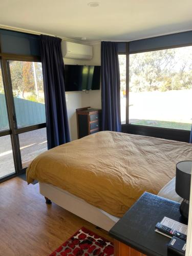 um quarto com uma cama e uma grande janela em Jerilderie BNB - Pets Welcome - House em Jerilderie