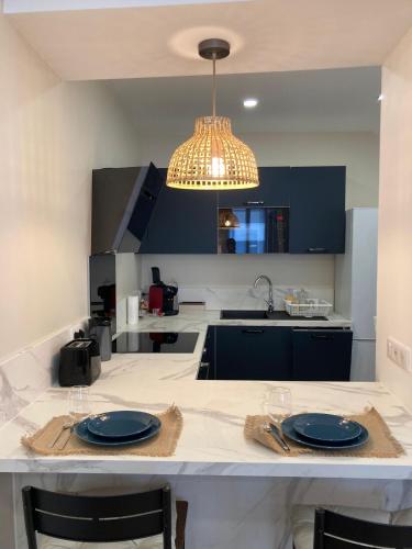 d'une cuisine avec une table et des plaques bleues. dans l'établissement Le Cottage Bellifontain proche Château - INSEAD - Grand Parquet, à Fontainebleau