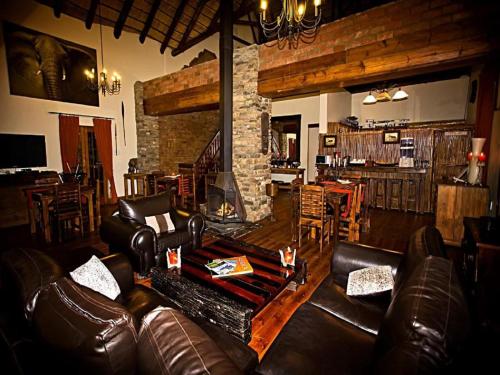 ein Wohnzimmer mit einem Ledersofa und einem Tisch in der Unterkunft Addo Bush Palace in Addo