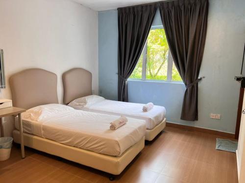 two beds in a bedroom with a window at Dear Dino Villa Cameron Highlands in Cameron Highlands