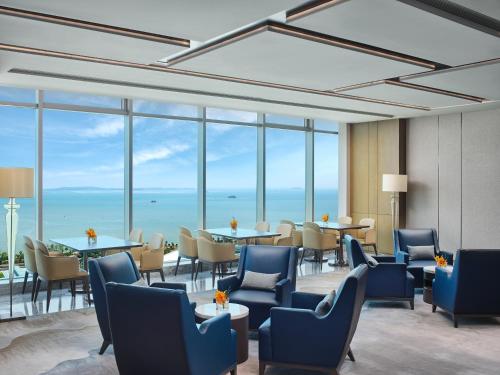 廈門的住宿－廈門宸洲洲際酒店，餐厅设有蓝色的椅子和桌子以及窗户。