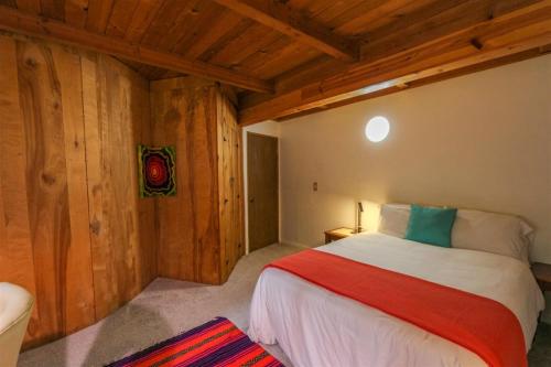 - une chambre avec un lit dans une pièce dotée de murs en bois dans l'établissement Sq Sequim Riverside, à Sequim