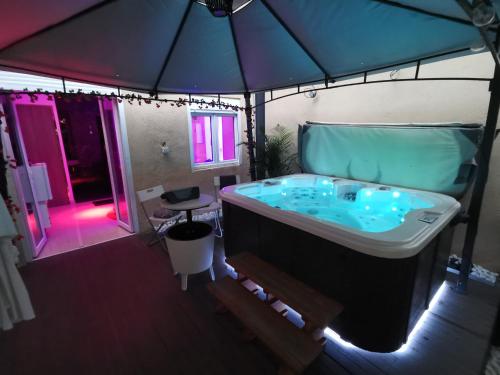 La salle de bains est pourvue d'une baignoire avec un parasol. dans l'établissement Lyon superbe jacuzzi vue sur jardin, à Villeurbanne