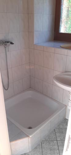 a white shower with a tub next to a sink at Prém Malom Vendégház in Bakonynána