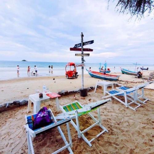 a beach with chairs and a street sign on it at Las Tortugas, Cozy condominium on Khao Tao beach, Hua Hin in Khao Tao