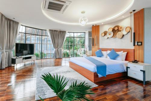 um quarto com uma cama grande e uma televisão em Bird Nest Villas by Mafiya em Sihanoukville