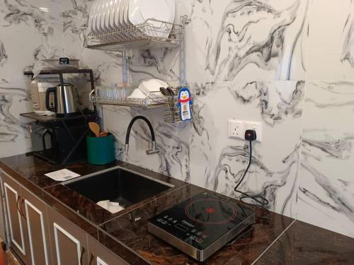 - une cuisine avec un évier et un mur en marbre dans l'établissement LAVIE HOTEL & APARTMENT, à Brinchang