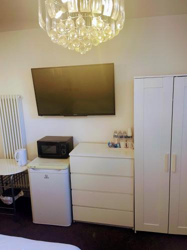 a room with a tv and a desk with a microwave at St George Hotel Great Yarmouth in Great Yarmouth
