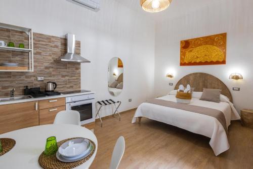 Il comprend une chambre avec un grand lit et une cuisine. dans l'établissement Lovely Rooms - Guest House Suites, à Triggiano