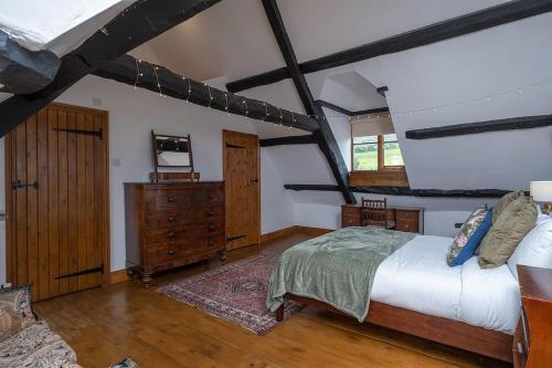 1 dormitorio con 1 cama y suelo de madera en Canons Court Lodge en Wotton under Edge