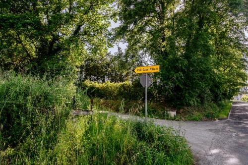 a yellow street sign on the side of a road at Villa La Quercia - Garden&Relax in Gavorrano