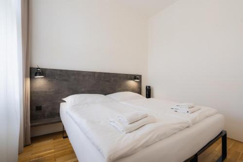 a white bed with white sheets and towels on it at EA ApartHotel Melantrich in Prague