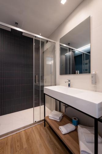 a bathroom with a large white sink and a shower at Hotel Sporting Riccione in Riccione