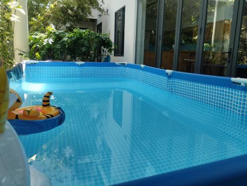 - une piscine en carrelage bleu avec un jouet dans un bateau dans l'établissement La Maison De Fleurs, à Đà Nẵng