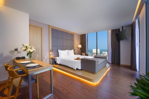 a hotel room with a bed and a table and a desk at Estrella Boutique Hotel in Da Nang