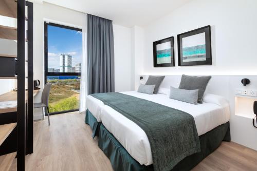 a hotel room with a large bed and a large window at Alexandre Fira Congress in Hospitalet de Llobregat